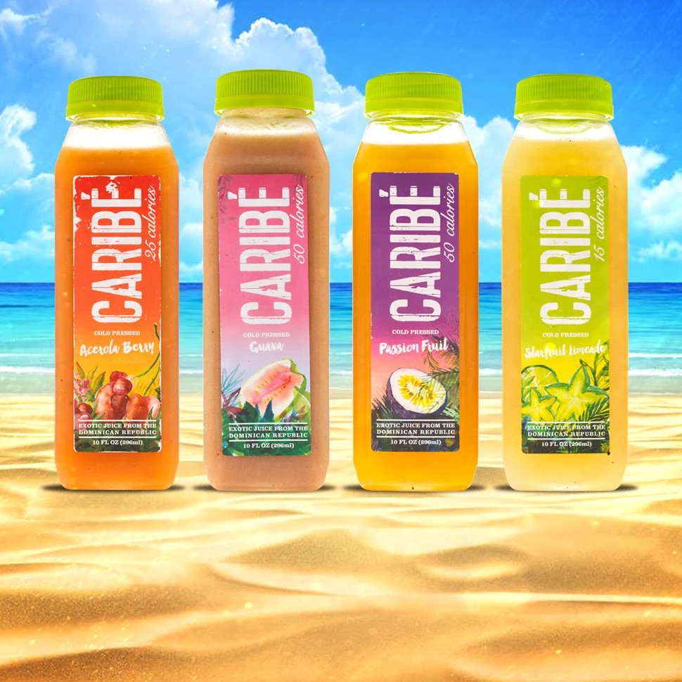 Four Caribe juice bottles with colorful labels and green caps