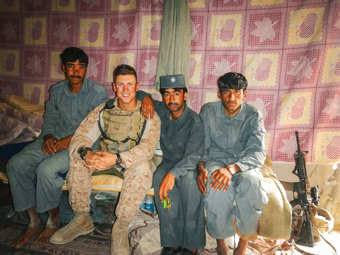 Marine seated with three men in uniform