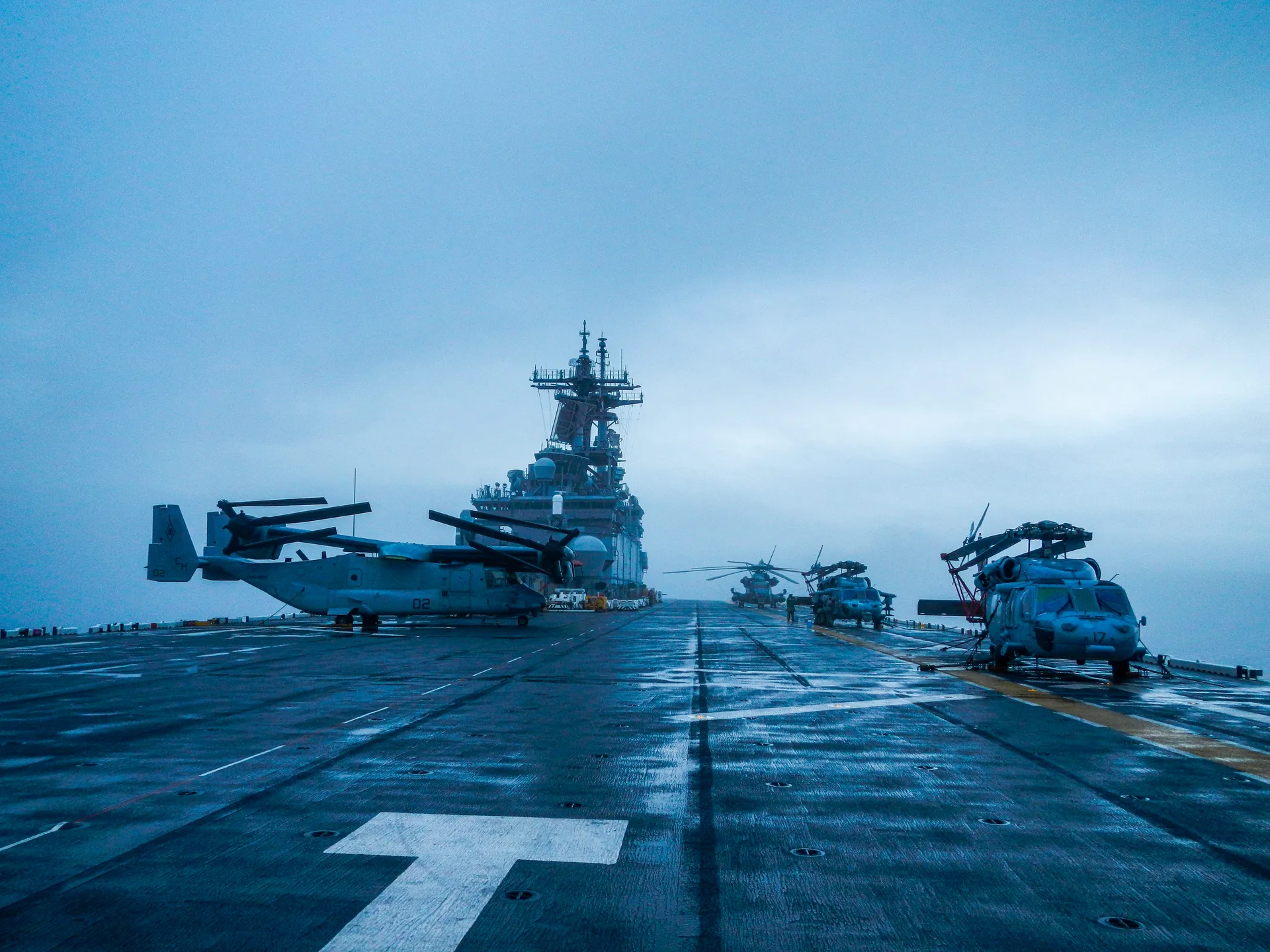 Helicopters and tiltrotor aircraft parked on a ship's flight deck