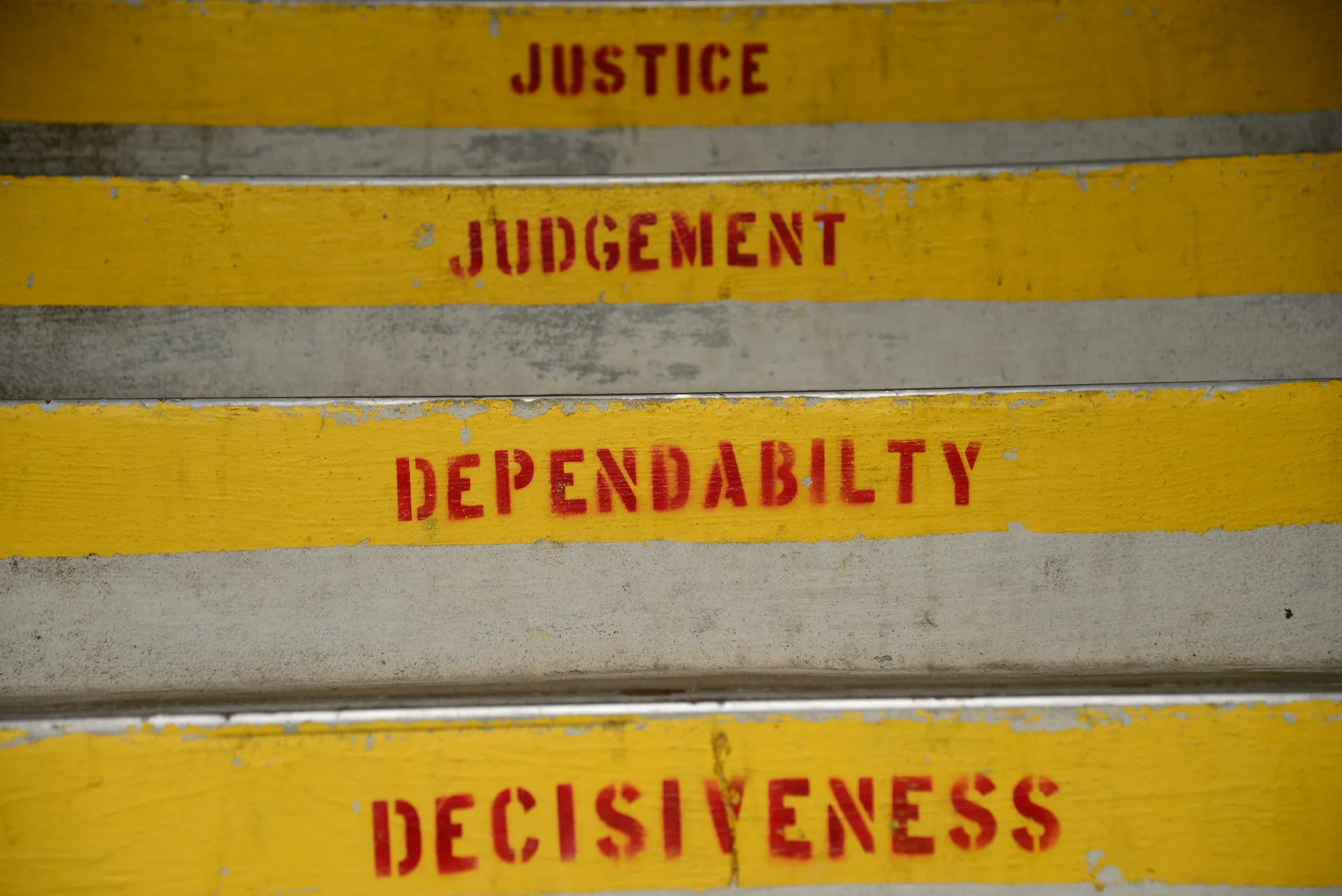 Yellow stair risers labeled Justice, Judgement, Dependability and Decisiveness